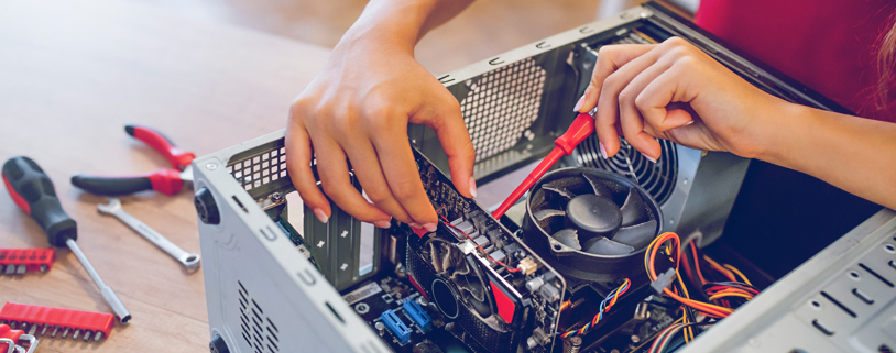 Technician performing micro-soldering on a motherboard